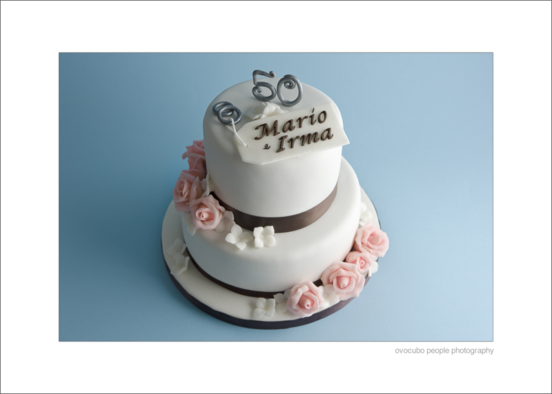 Immagine di torta a due piani con rose rosa e fiori bianchi